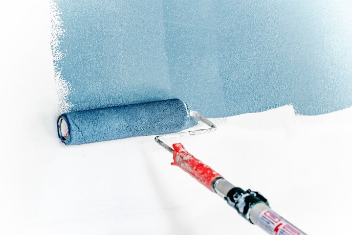 Painter rolling paint onto a wall